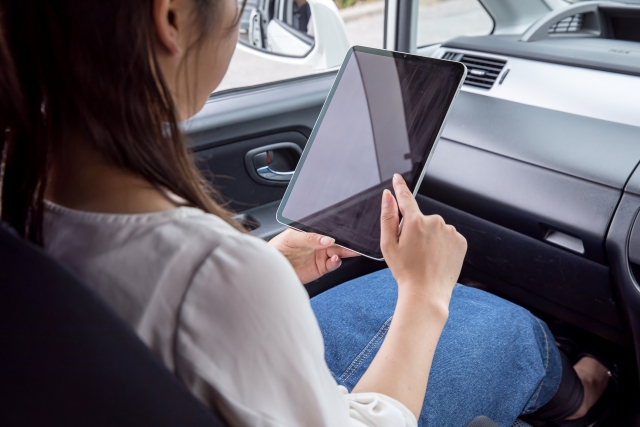 移動中にタブレットで学習している女性